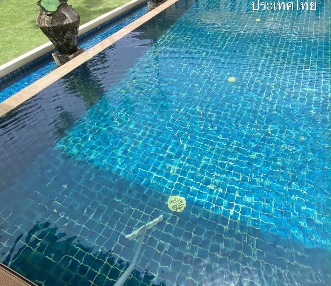 Brushing the floor of a villa pool in Phuket